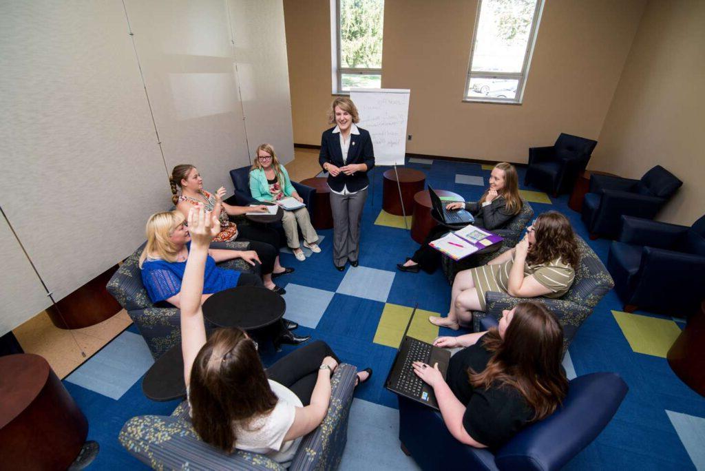 A group of female students in a circle having a business meeting.